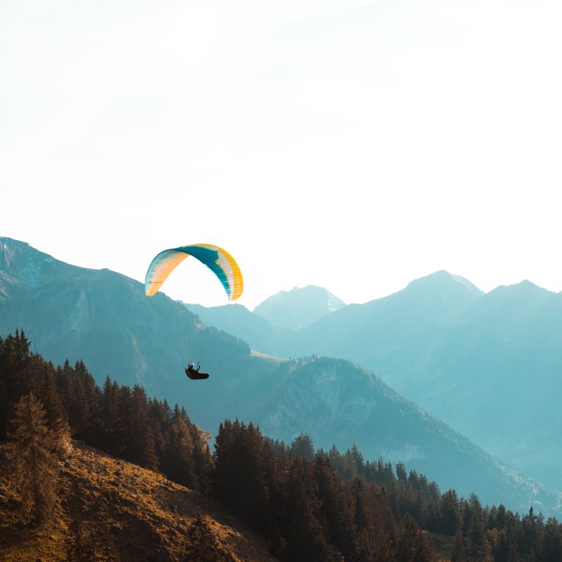a man flying through the air on top of a mountain